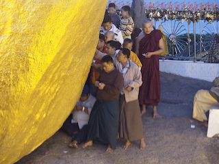 worshipers sticking gold leaves on the Golden Rock, Golden Rock • Myanmar