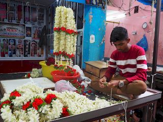 making a flower necklace in the market, Mysore • India • Karnataka
